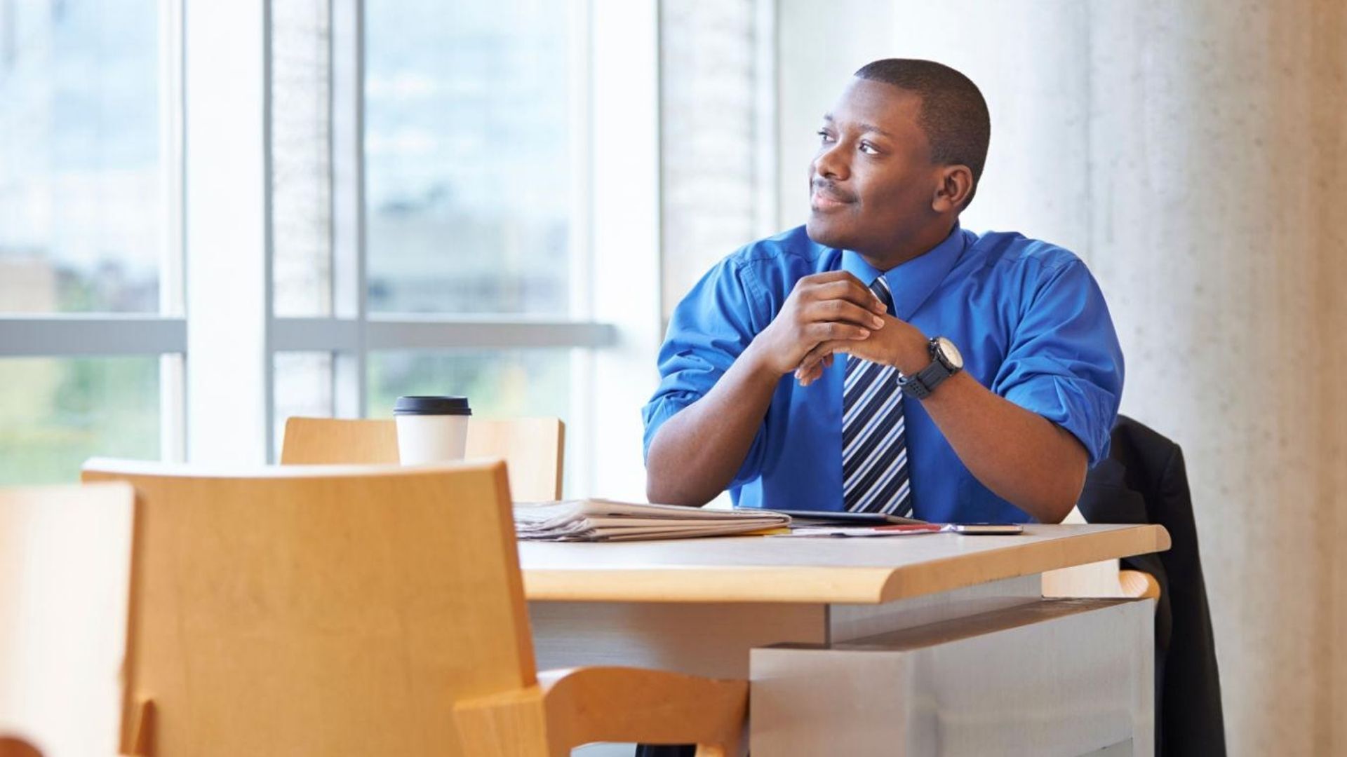 man looking into the distance out the window in the workplace