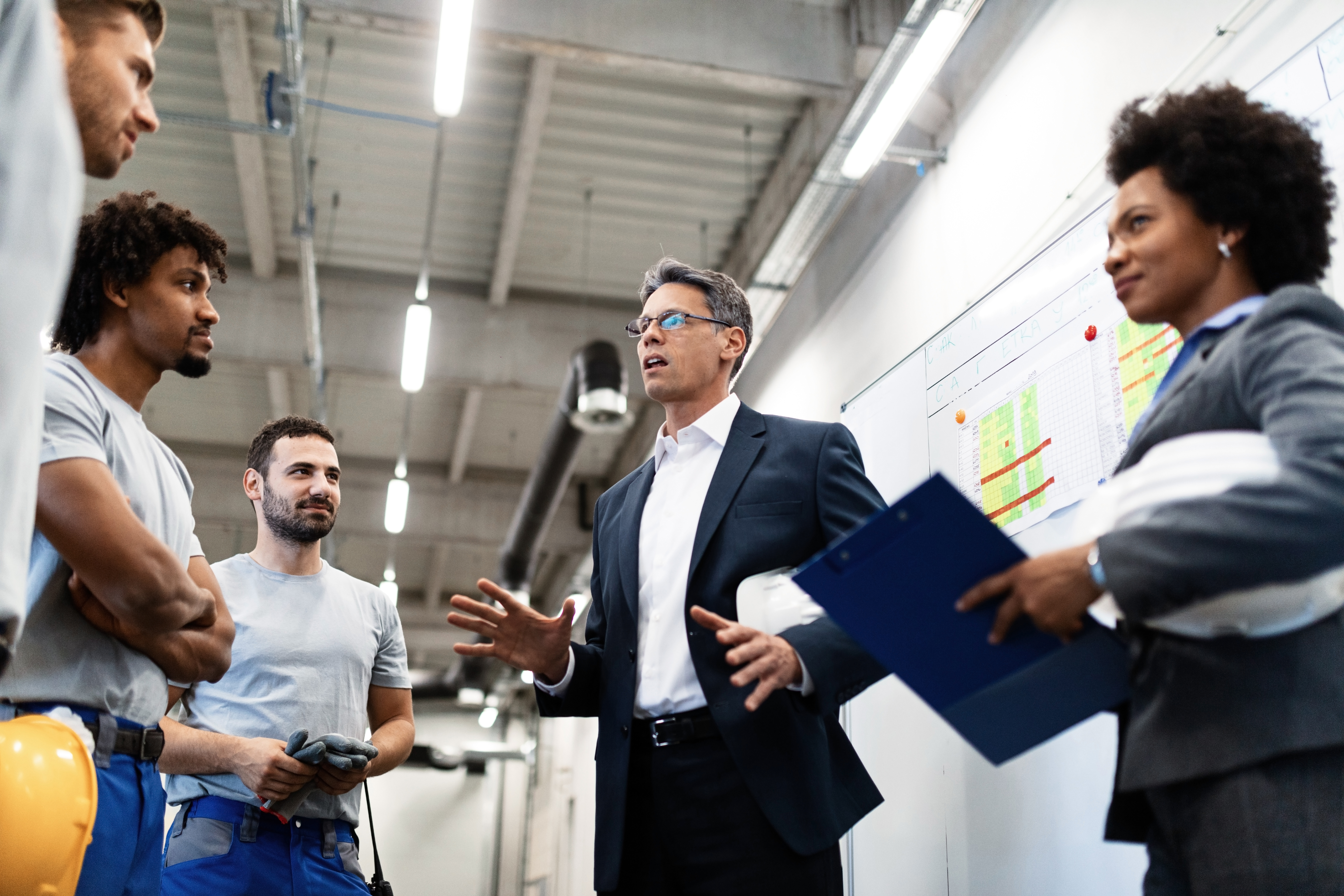 Factory manager holding a meeting and talking to his employees about project plans
