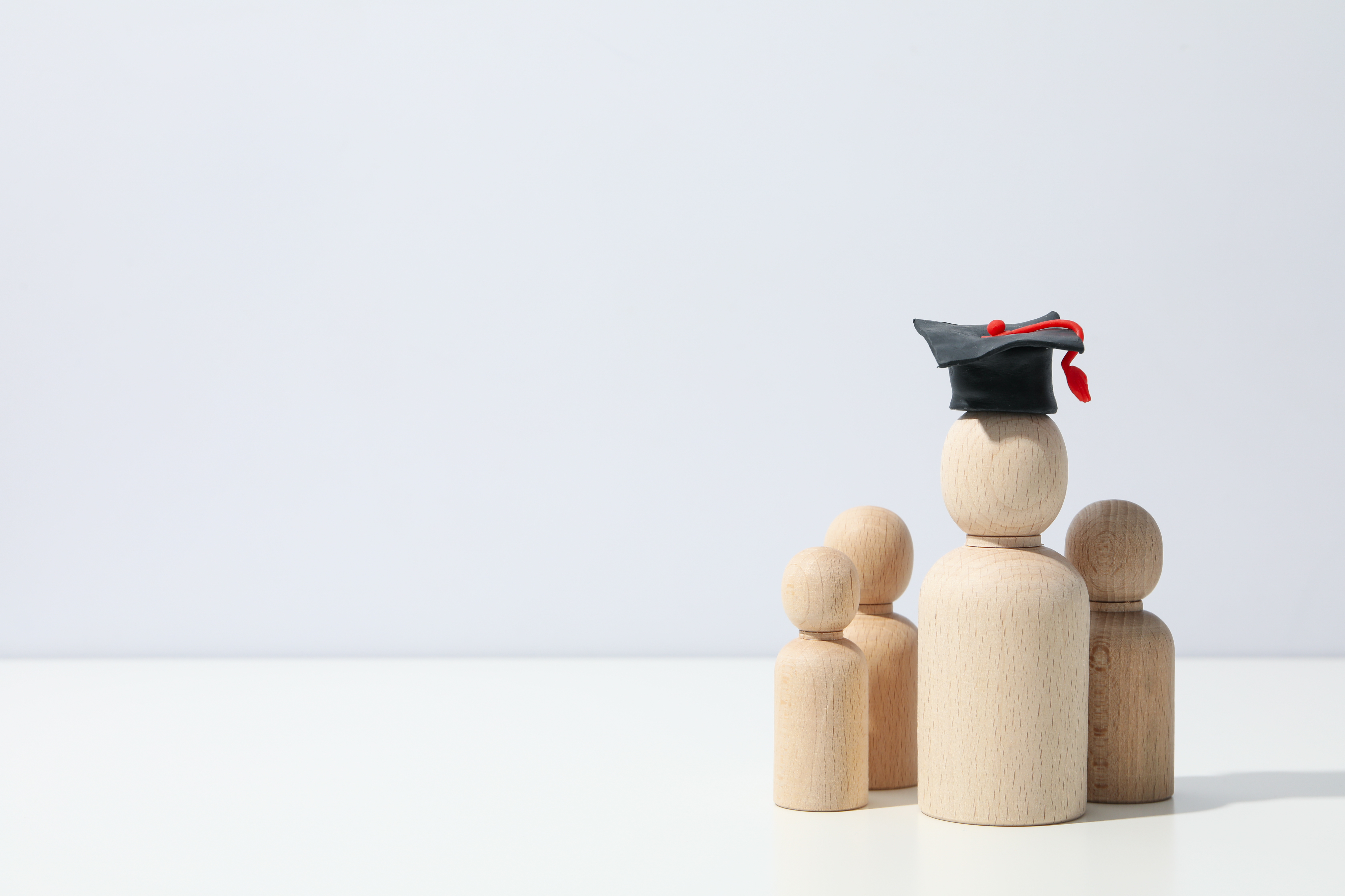 wooden figures with graduation cap