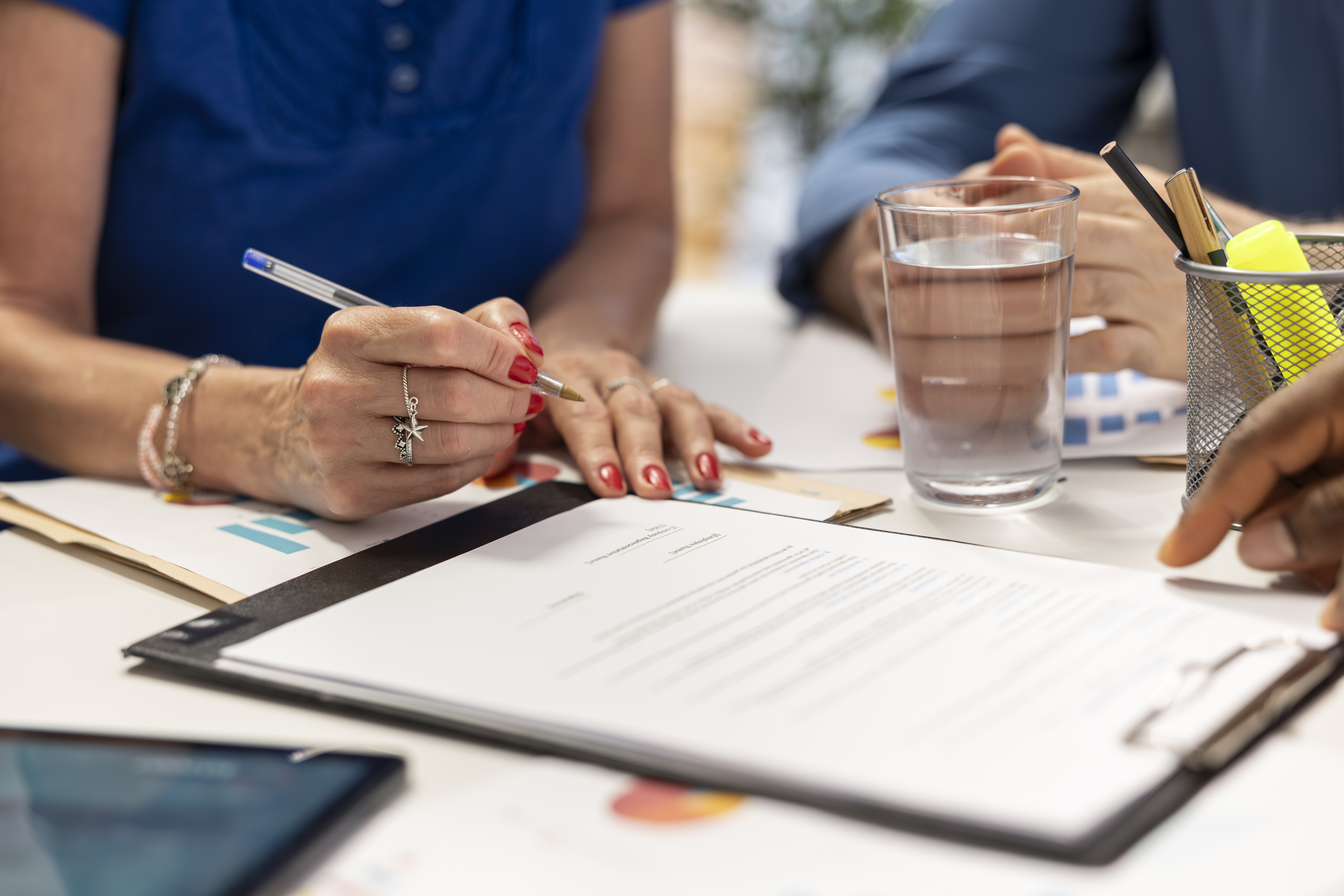 Senior woman signing the new retirement plan contract in a meeting