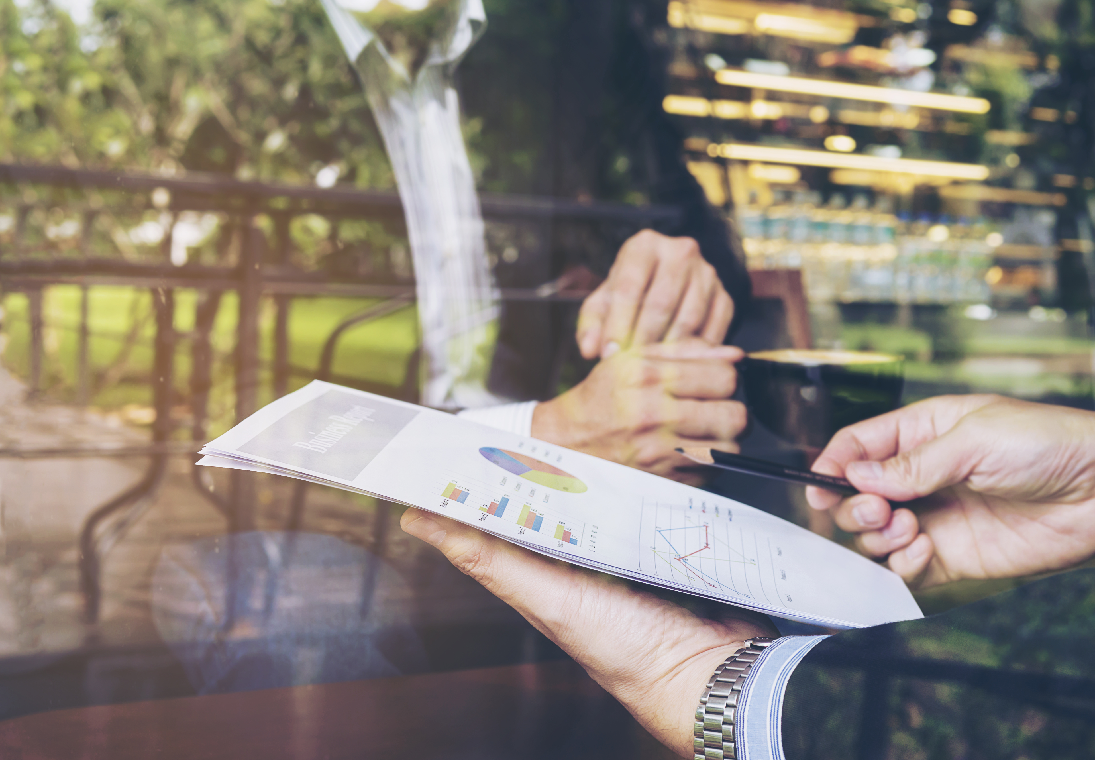 Two businessman discussing their report in coffee shop